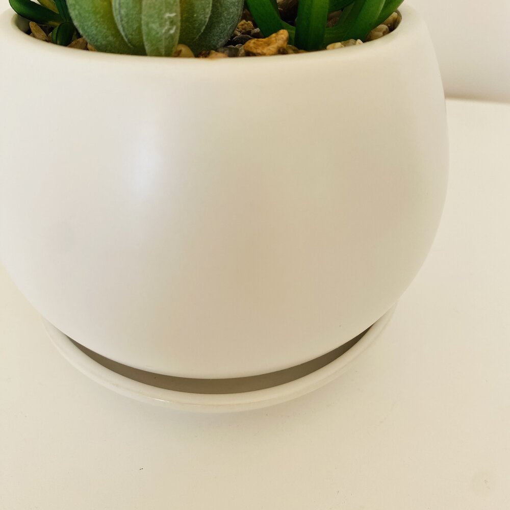 Vaso branco redondo com planta artificial verde e pedras decorativas