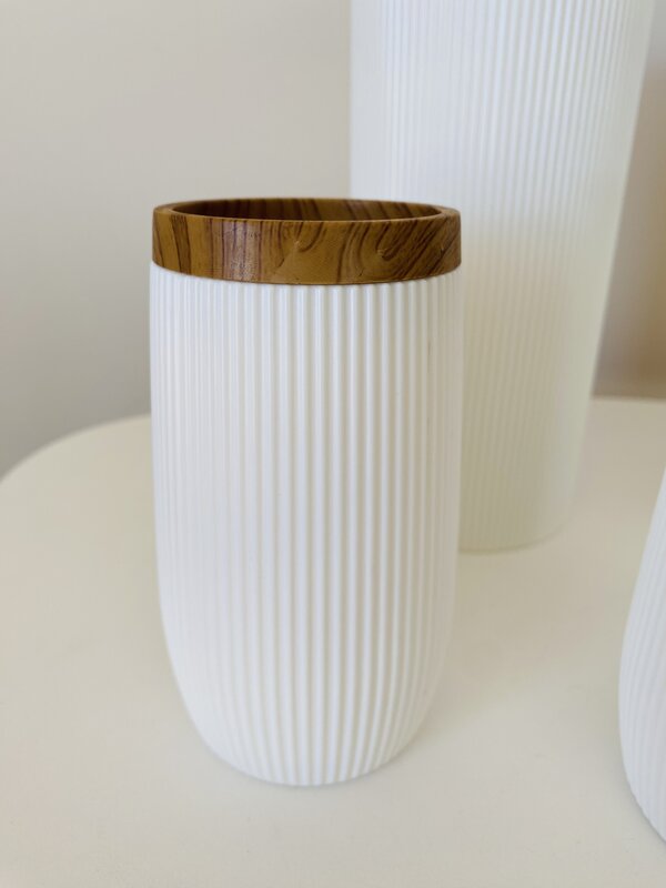 Recipiente branco com tampa de madeira castanha e textura estriada