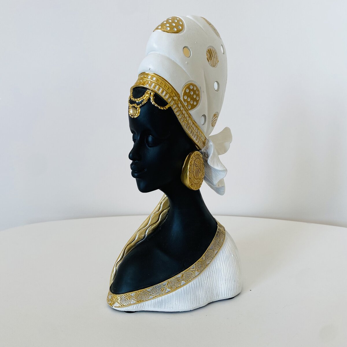 Escultura de busto feminino preto com turbante branco e dourado