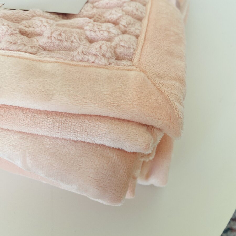 Toalha de banho cor de rosa clara com padrão acolchoado em relevo