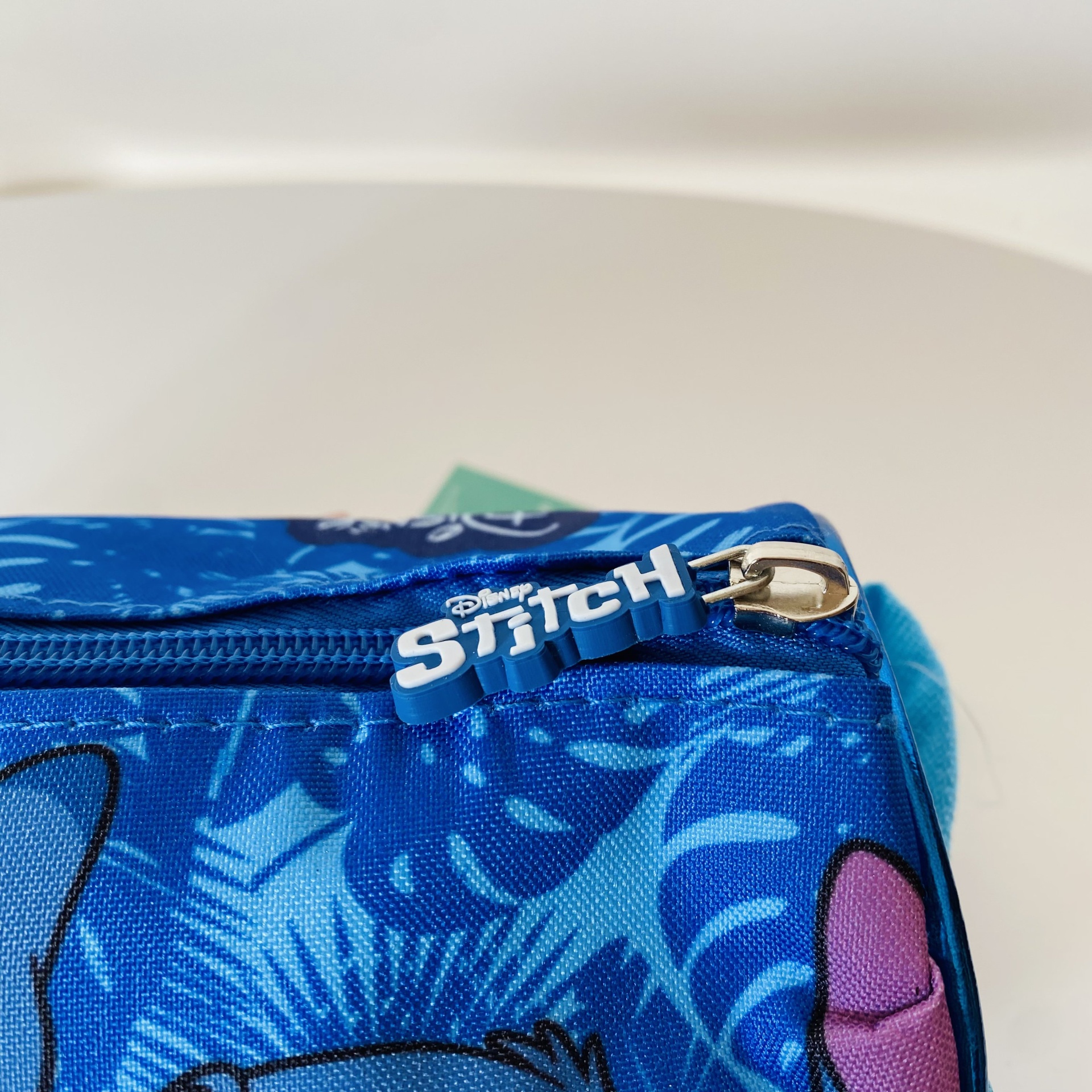 Mochila azul com padrão do Stitch da Disney com zipper e puxador branco