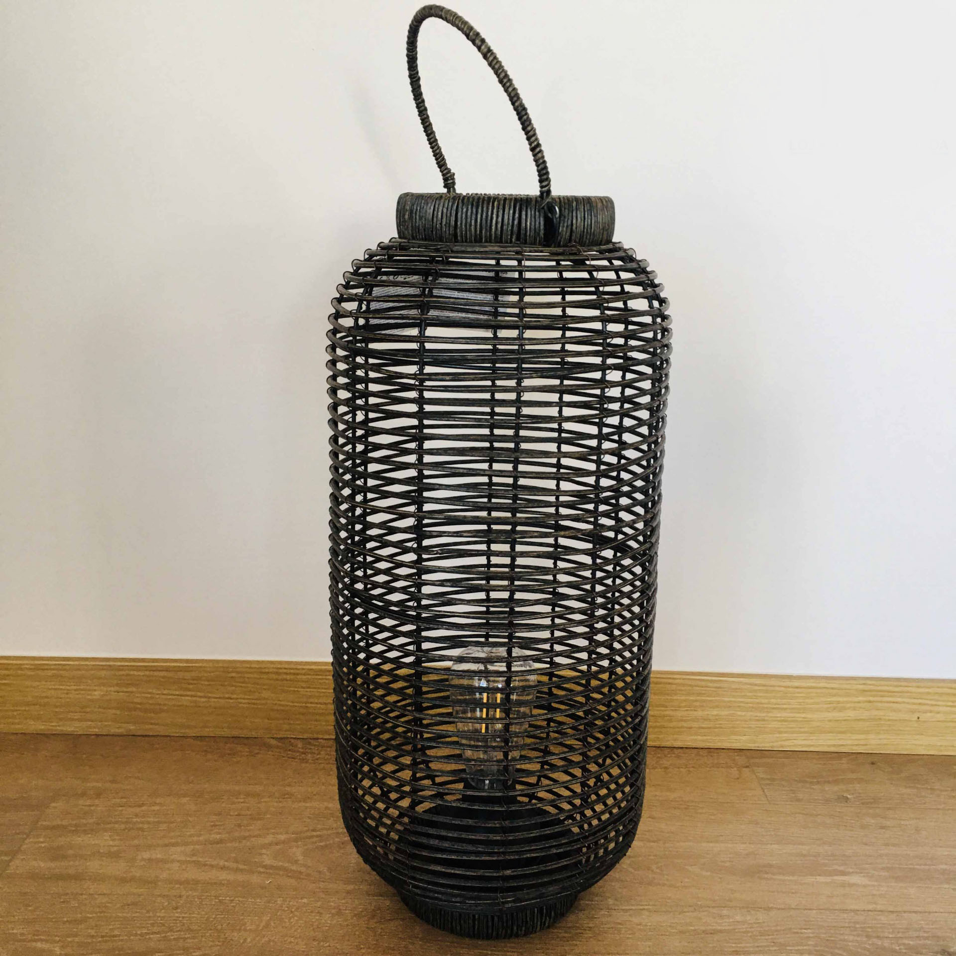 Lanterna preta de fibras entrelaçadas com formato cilíndrico e alça superior