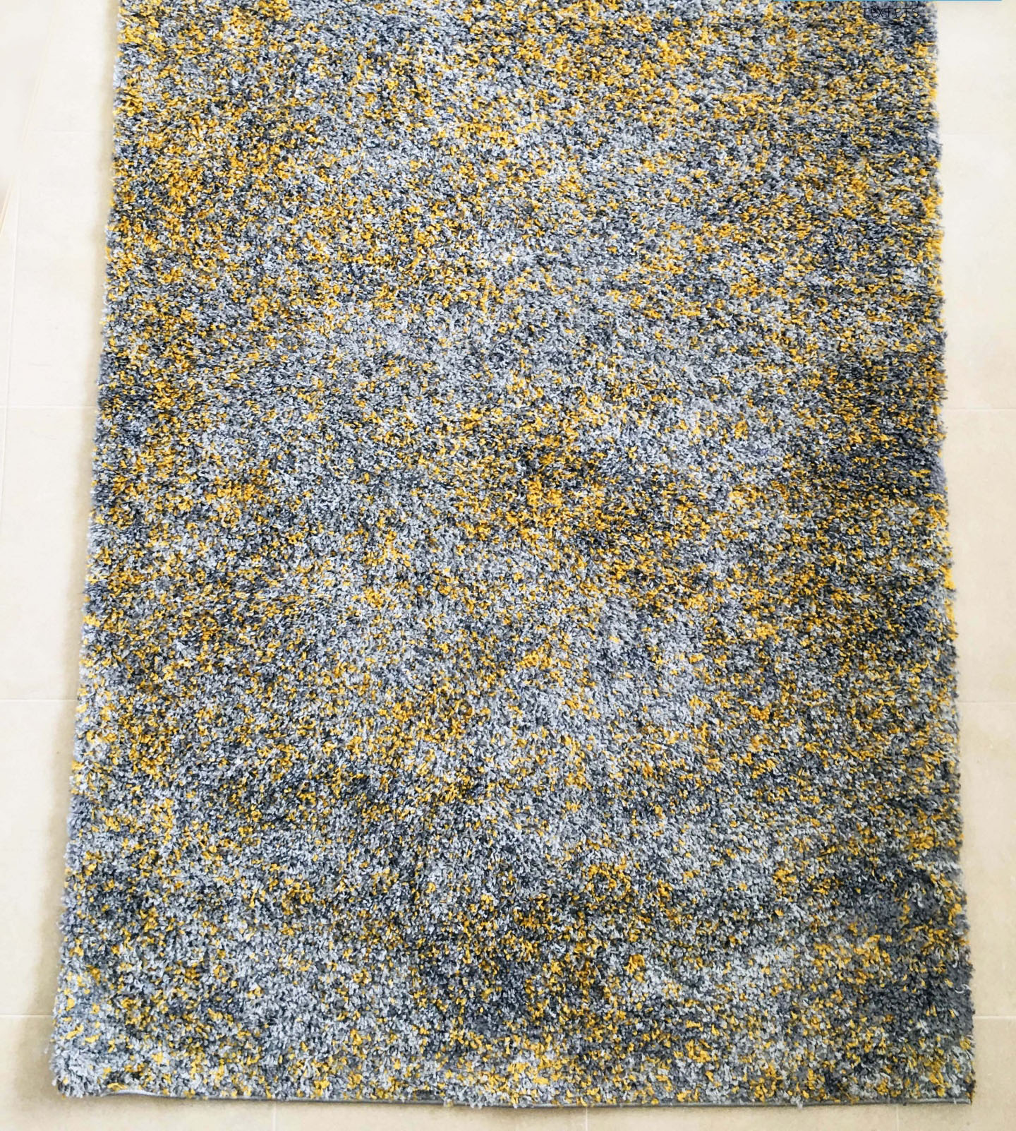 Tapete felpudo cinza, amarelo e azul com padrão abstrato