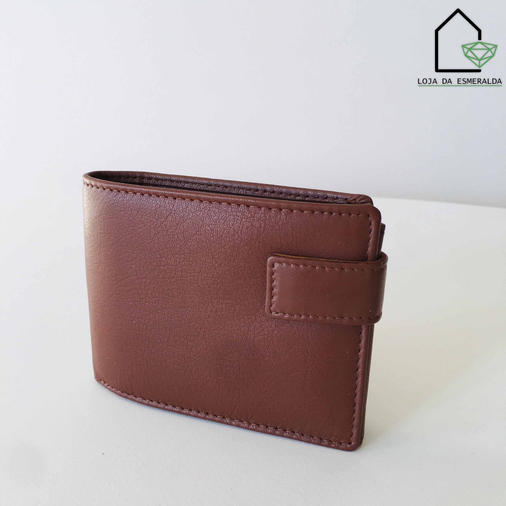 Carteira masculina castanha com fecho por aba sobre superfície branca