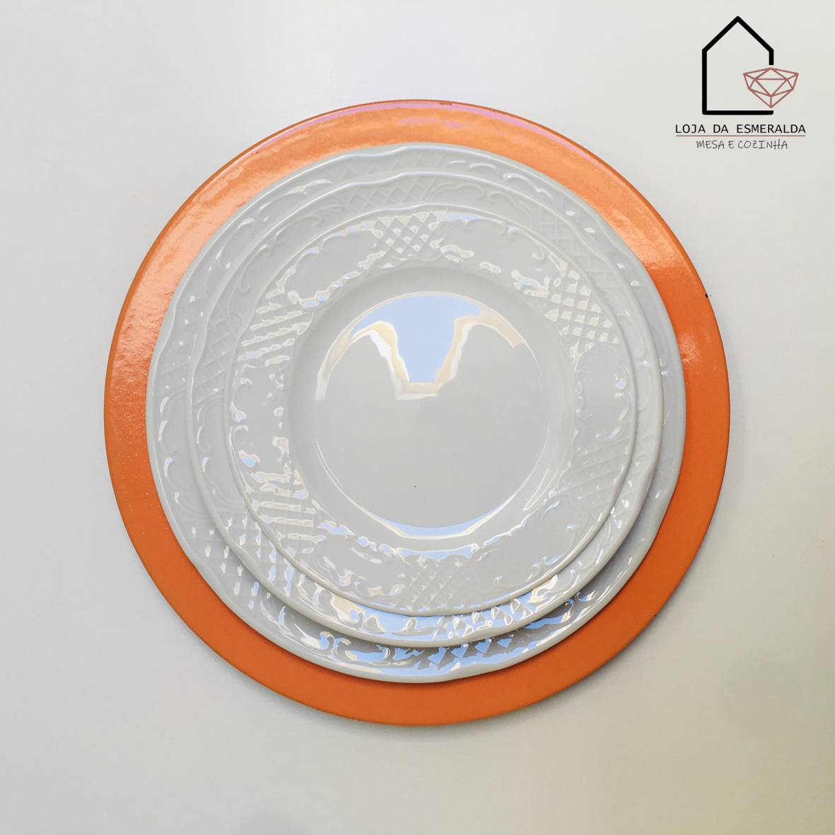 Conjunto de pratos brancos com textura sobre prato orange e fundo branco com logo