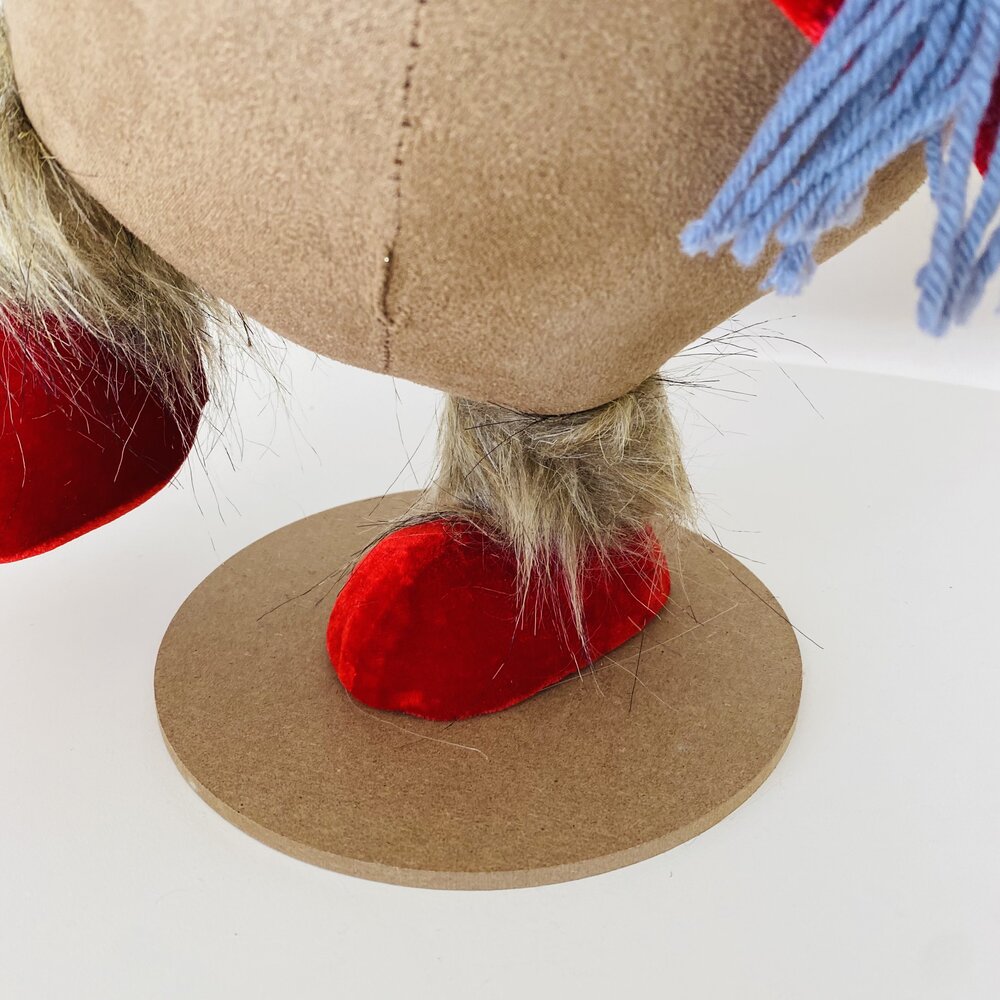 Peça decorativa com base redonda em madeira e pés vermelhos com pêlo sintético