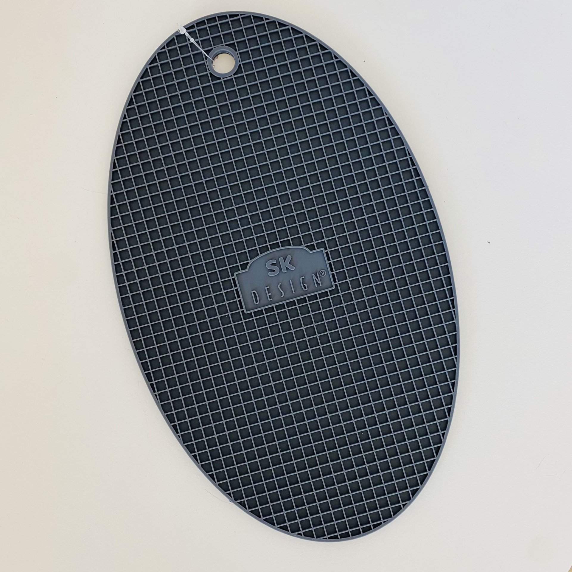 Produto oval preto com textura quadriculada e texto SK DESIGN