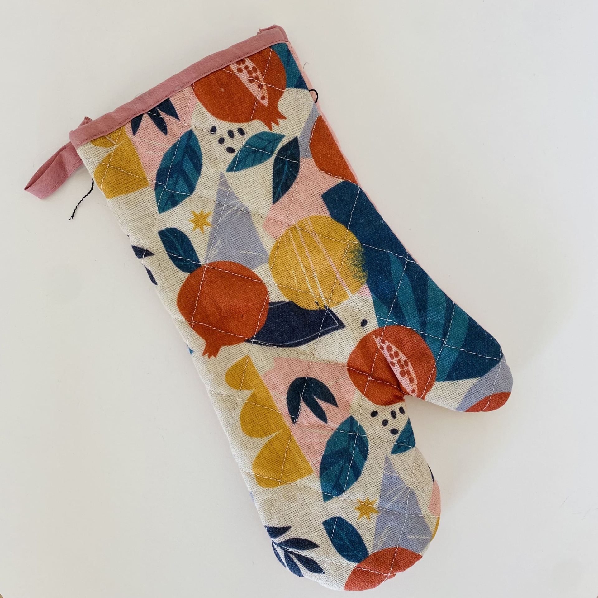 Luva de forno colorida com padrão de folhas e frutas