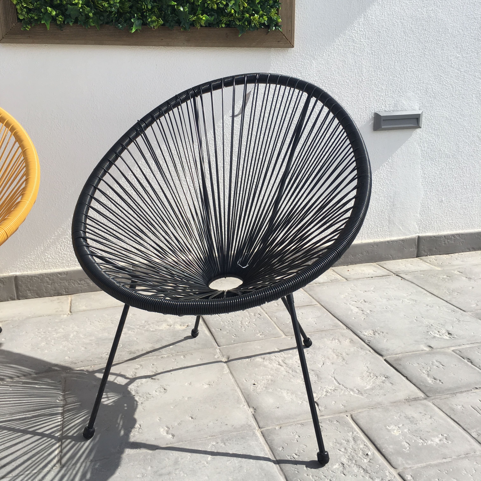 Cadeira exterior redonda preta com padrão de cordas entrelaçadas