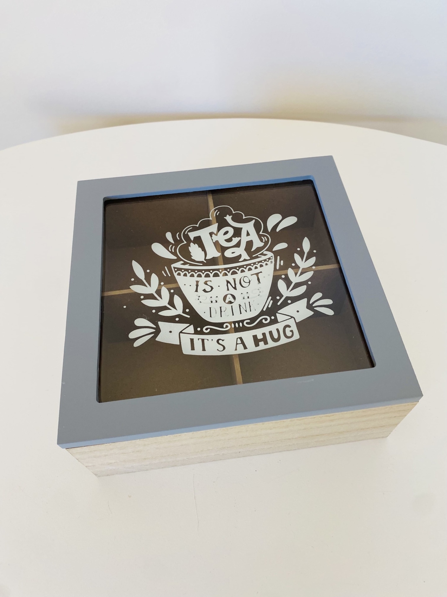 Caixa de madeira para chá com tampa em vidro e moldura cinzenta, decorada com texto branco