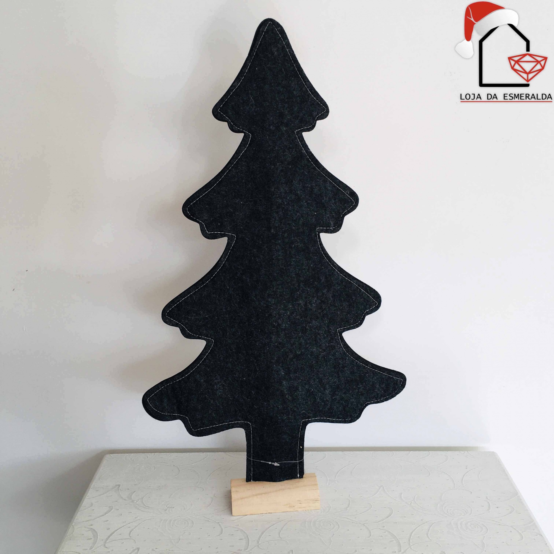 Árvore de Natal decorativa de feltro preto com base de madeira sobre superfície clara
