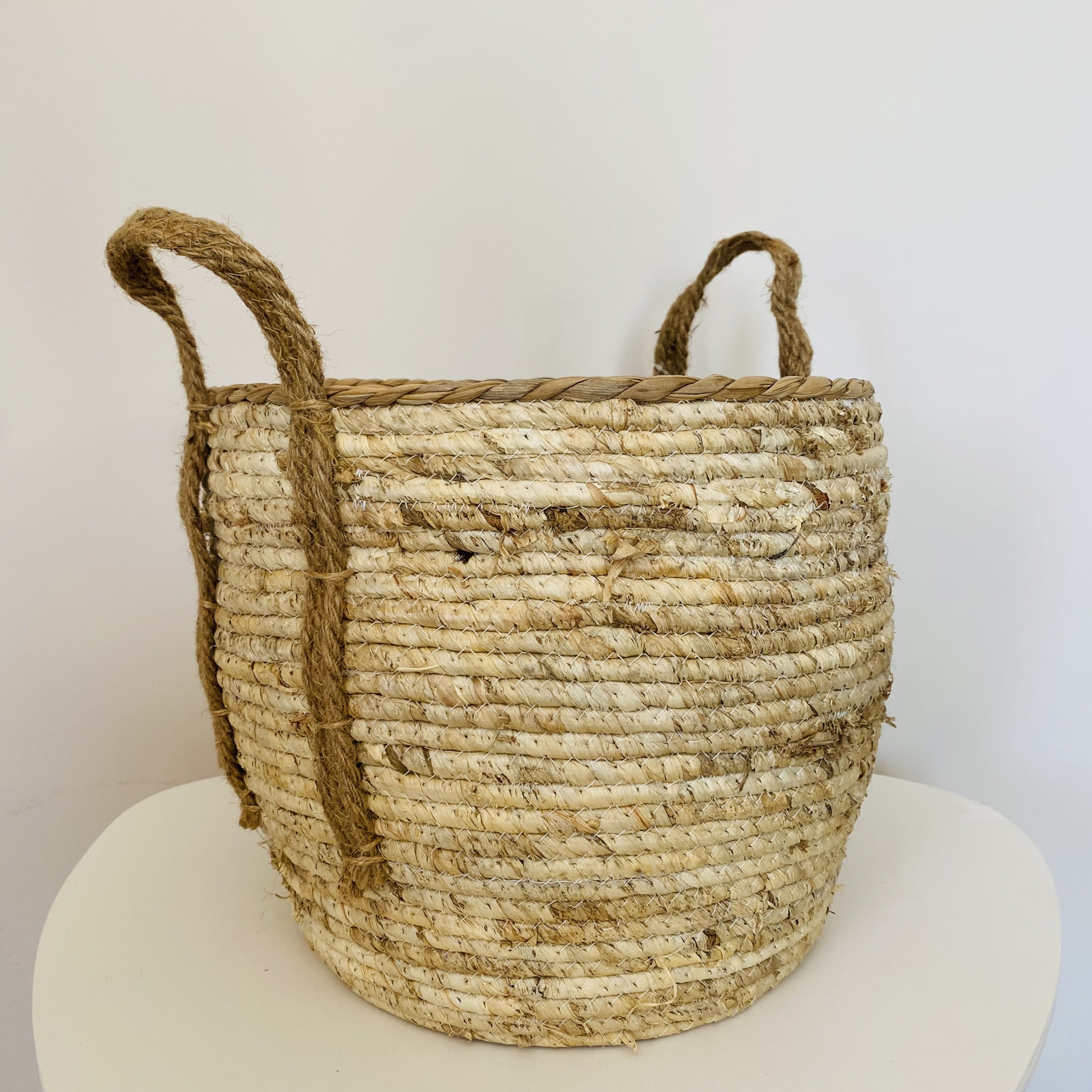 Cesto redondo trançado com duas pegas em fibra natural