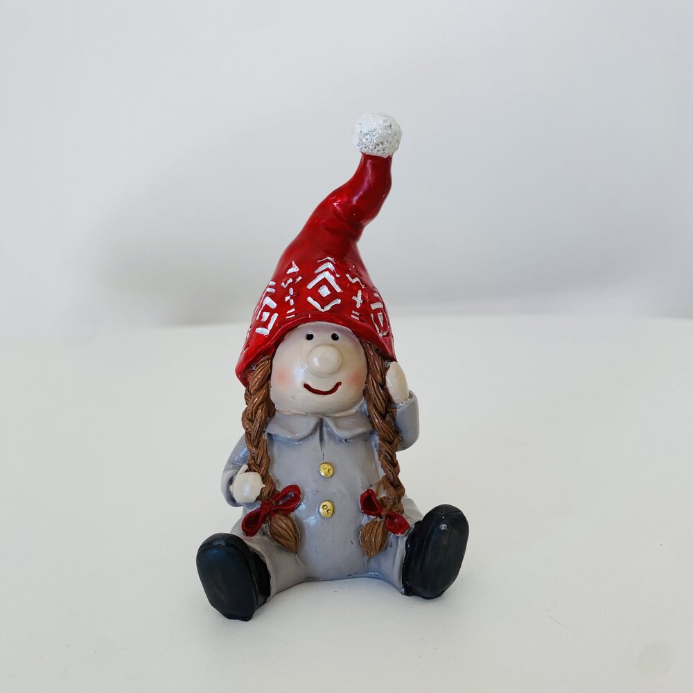 Figura de gnomo decorativo com chapéu vermelho com padrões brancos