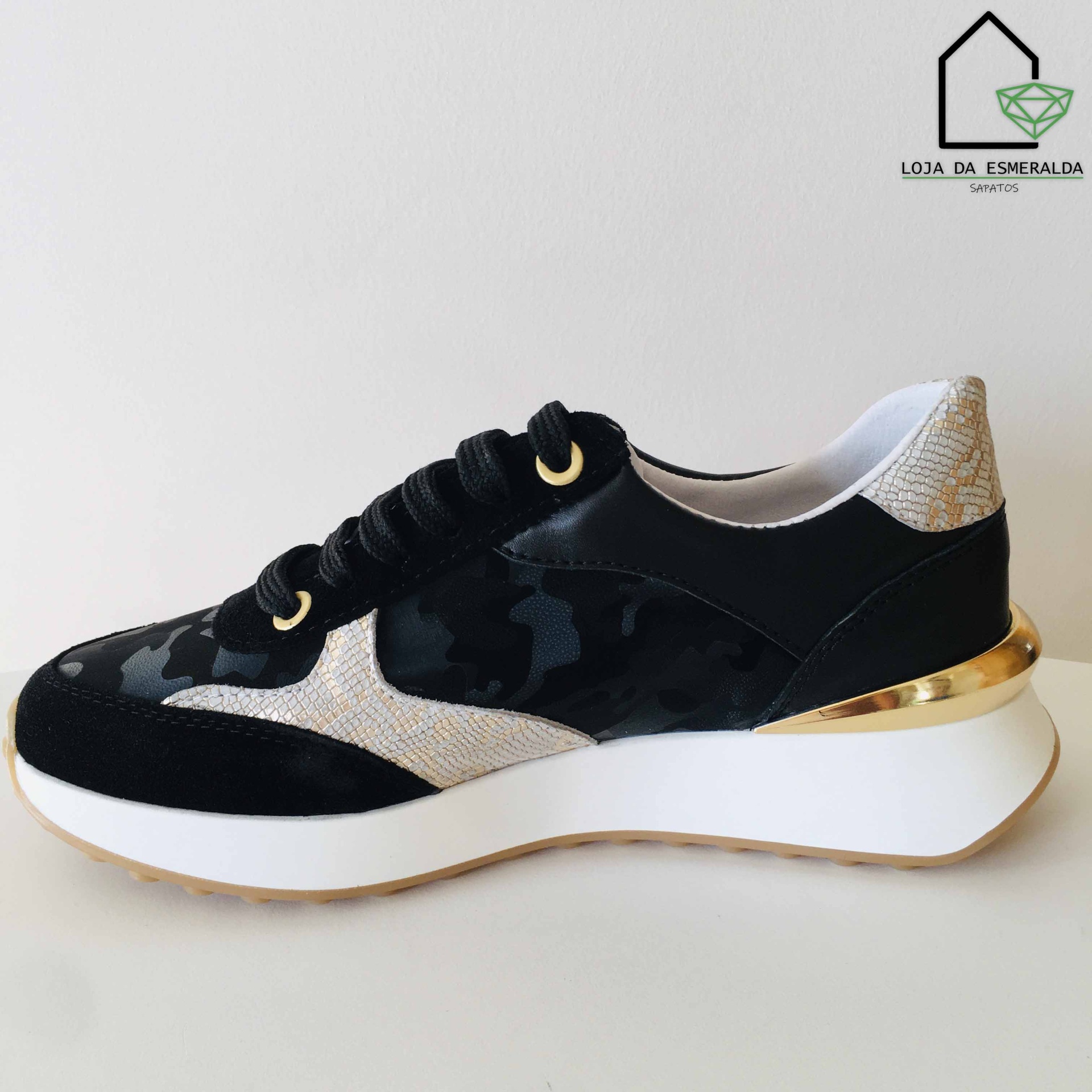 Sapatilha preta com sola branca e detalhe dourado no calcanhar