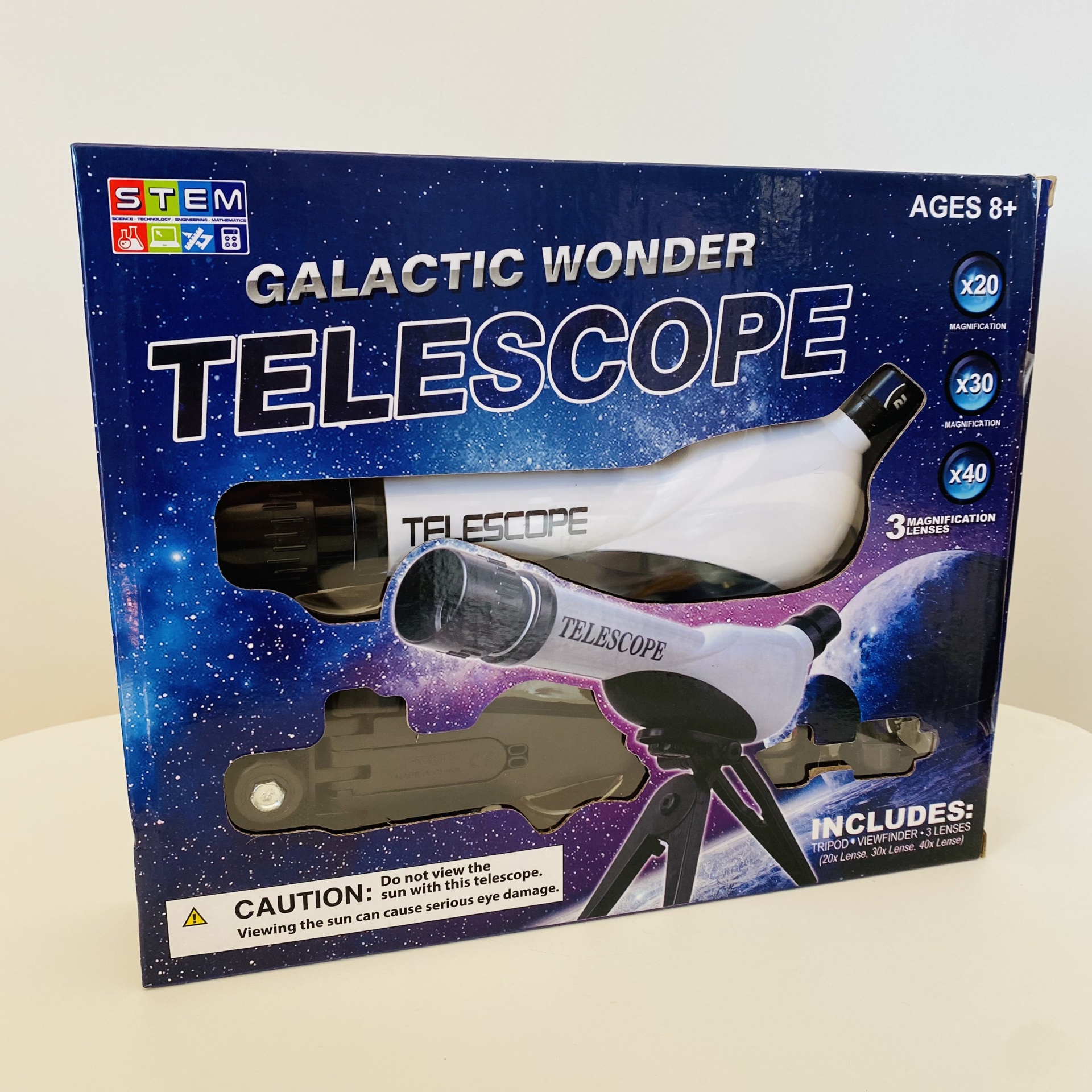 Caixa azul com imagem de telescópio branco e preto e texto GALACTIC WONDER TELESCOPE