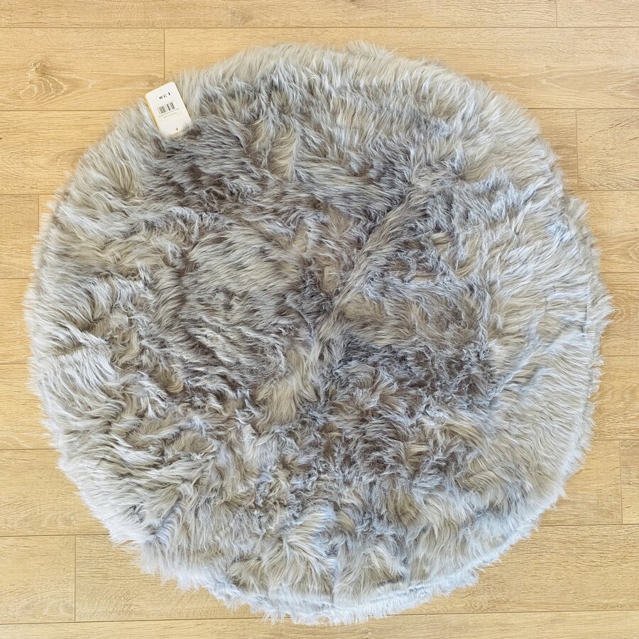 Tapete redondo peludo cinza sobre chão de madeira