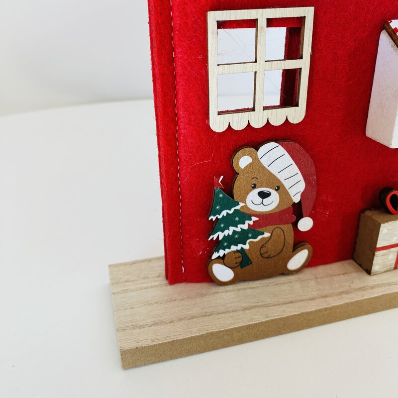 Decoração natalícia com urso em madeira e parede vermelha