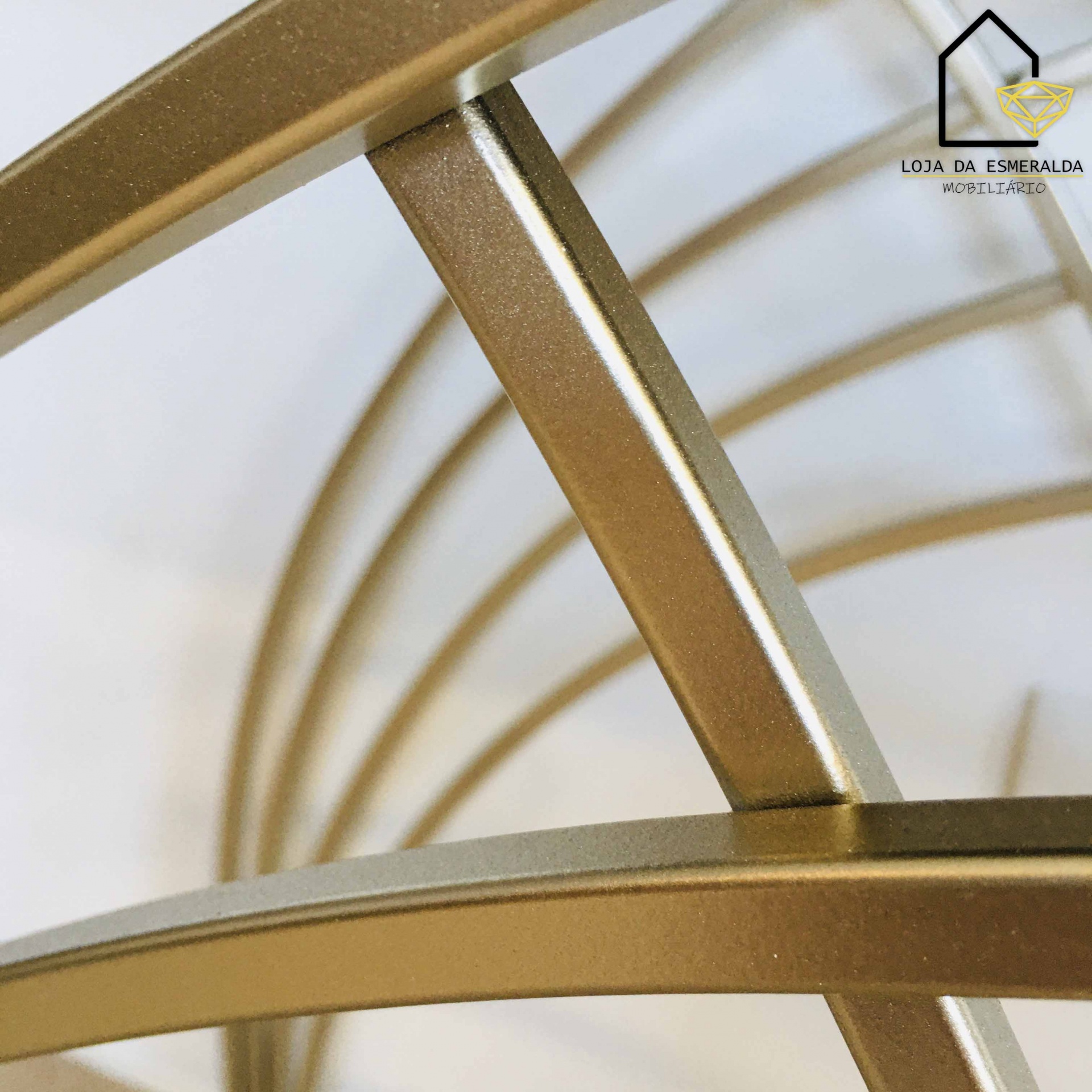 Estrutura metálica dourada com design circular e logótipo da Loja da Esmeralda