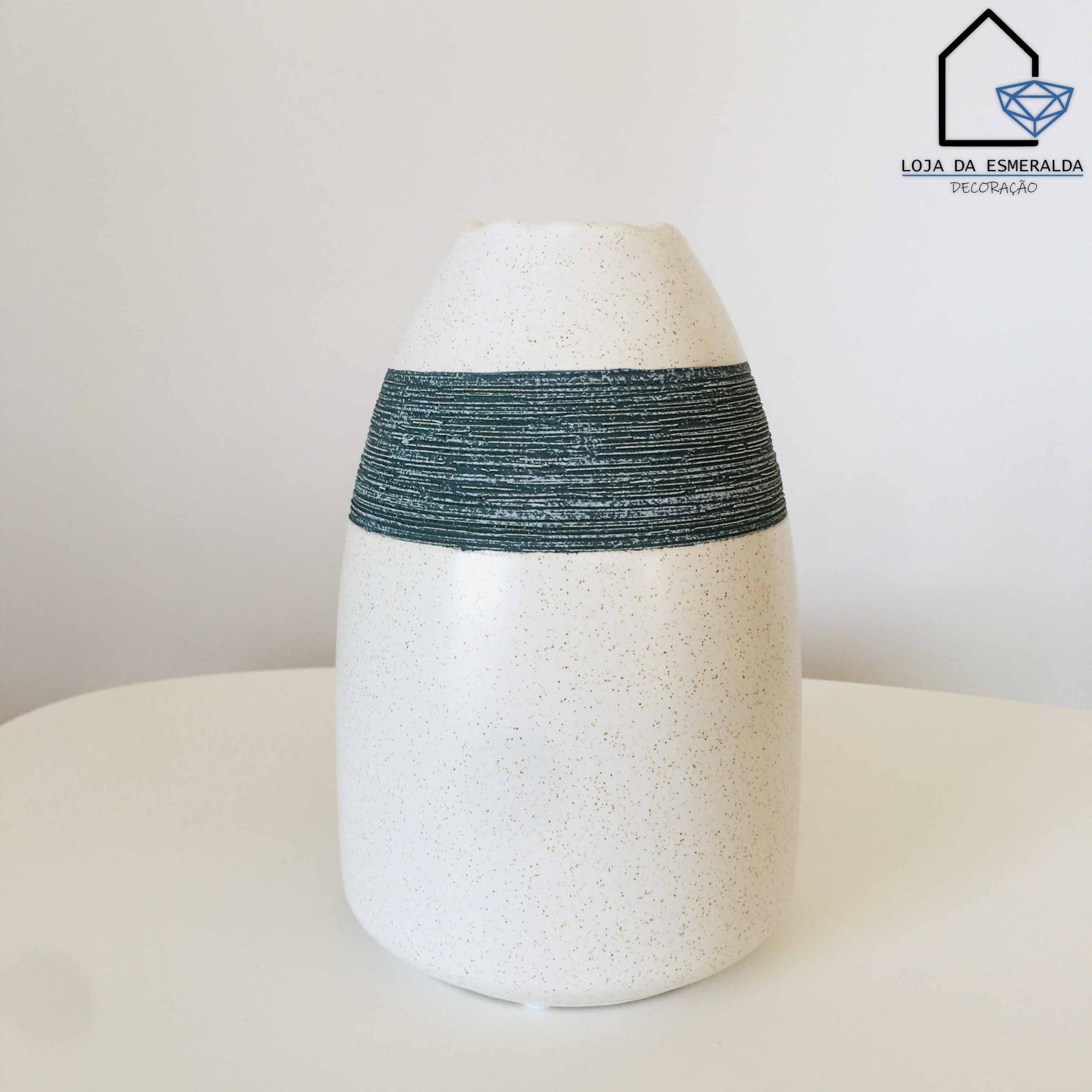 Vaso cerâmico branco com faixa verde texturizada e logotipo Loja da Esmeralda Décoração na parede