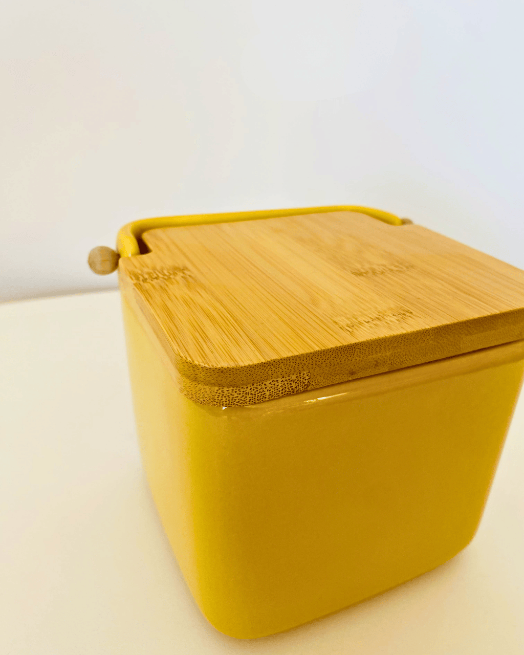 Recipiente cúbico amarelo com tampa de madeira clara
