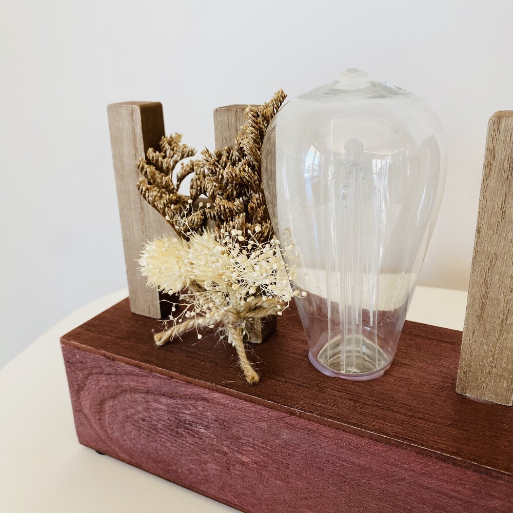 Suporte de madeira castanha com bulbo de vidro transparente e flores secas decorativas