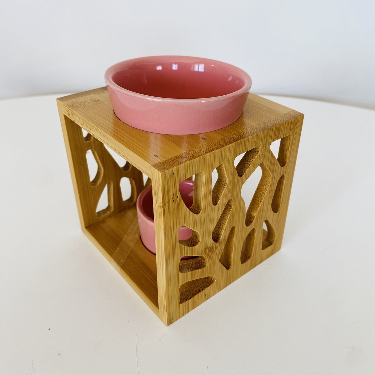 Suporte de madeira com padrão recortado e recipientes cerâmicos cor-de-rosa