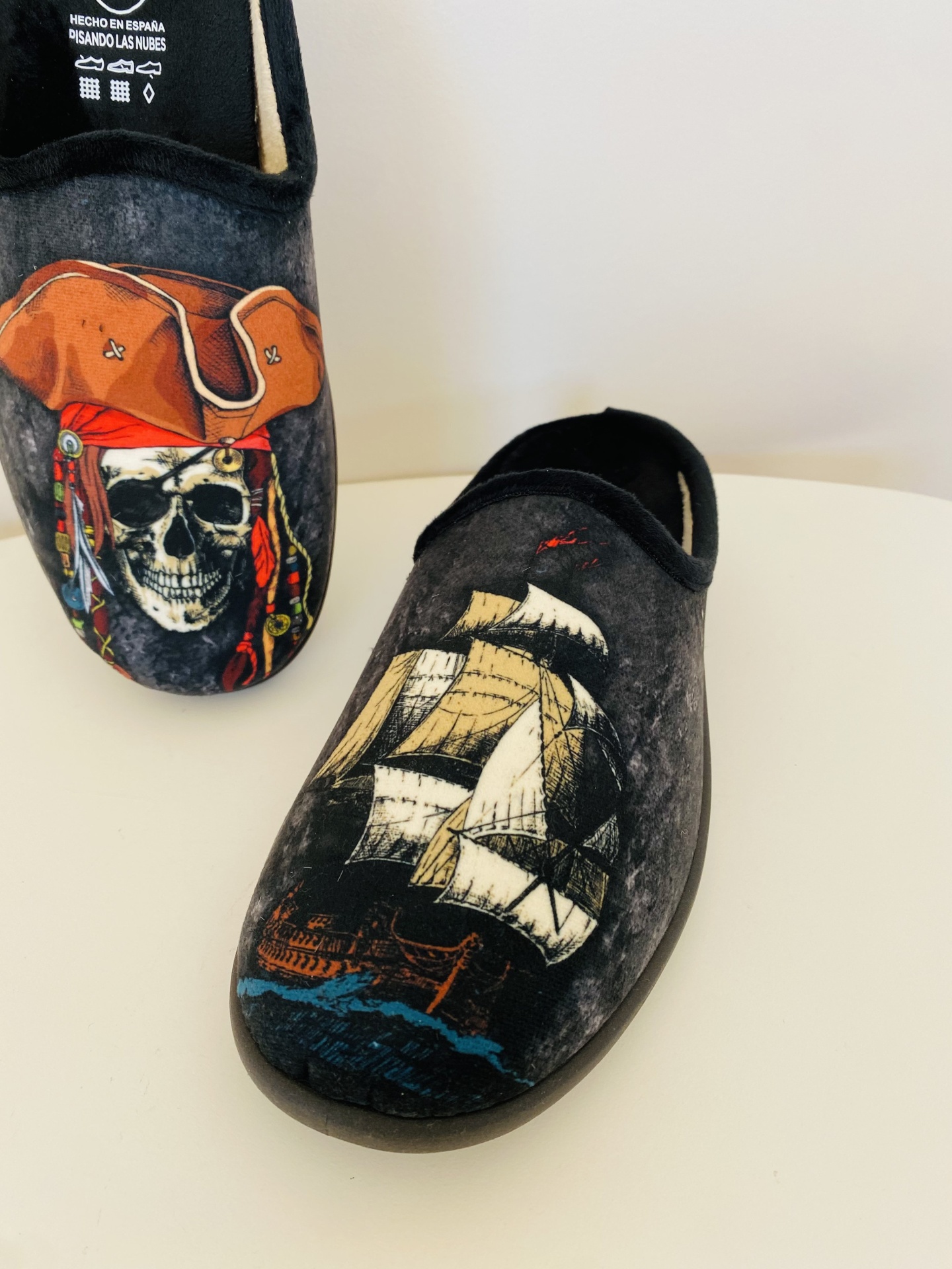 Chinelos cinza escuro com desenhos de pirata e navio.