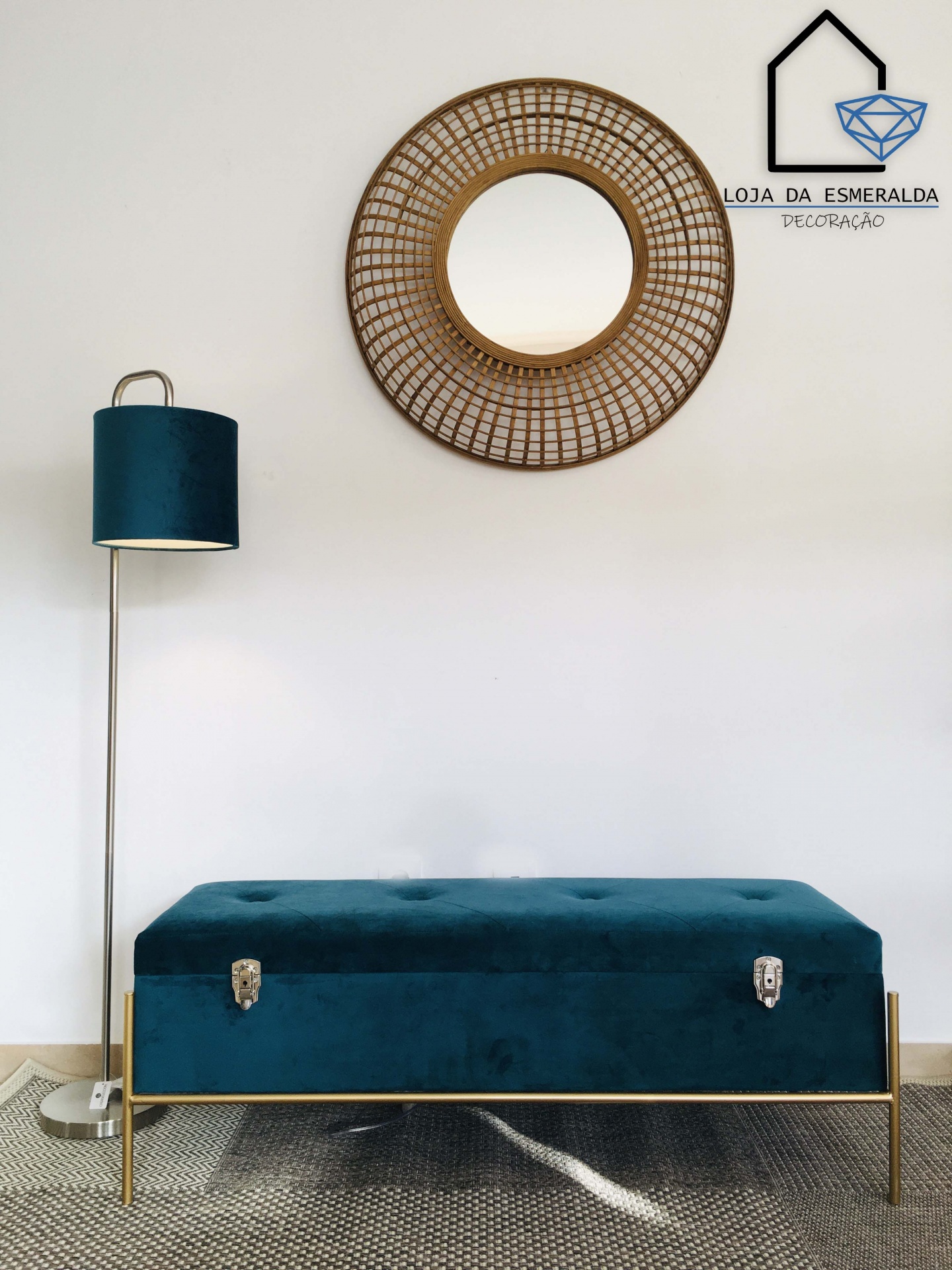 Decoração interior com espelho redondo de madeira, lâmpada de pé azul turquesa e banco estofado azul turquesa com estrutura dourada.