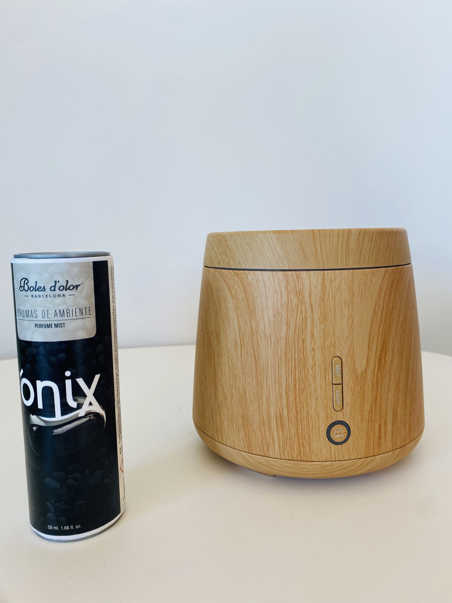 Difusor de ambiente em madeira clara e frasco de ambientador spray preto