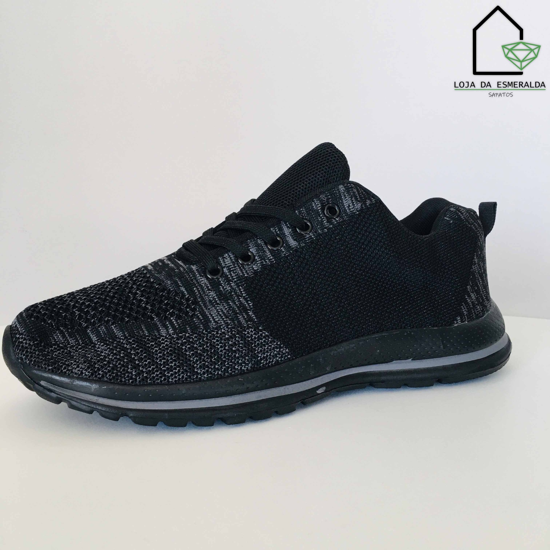 Tênis desportivo preto e cinza sobre superfície branca com logótipo Loja da Esmeralda