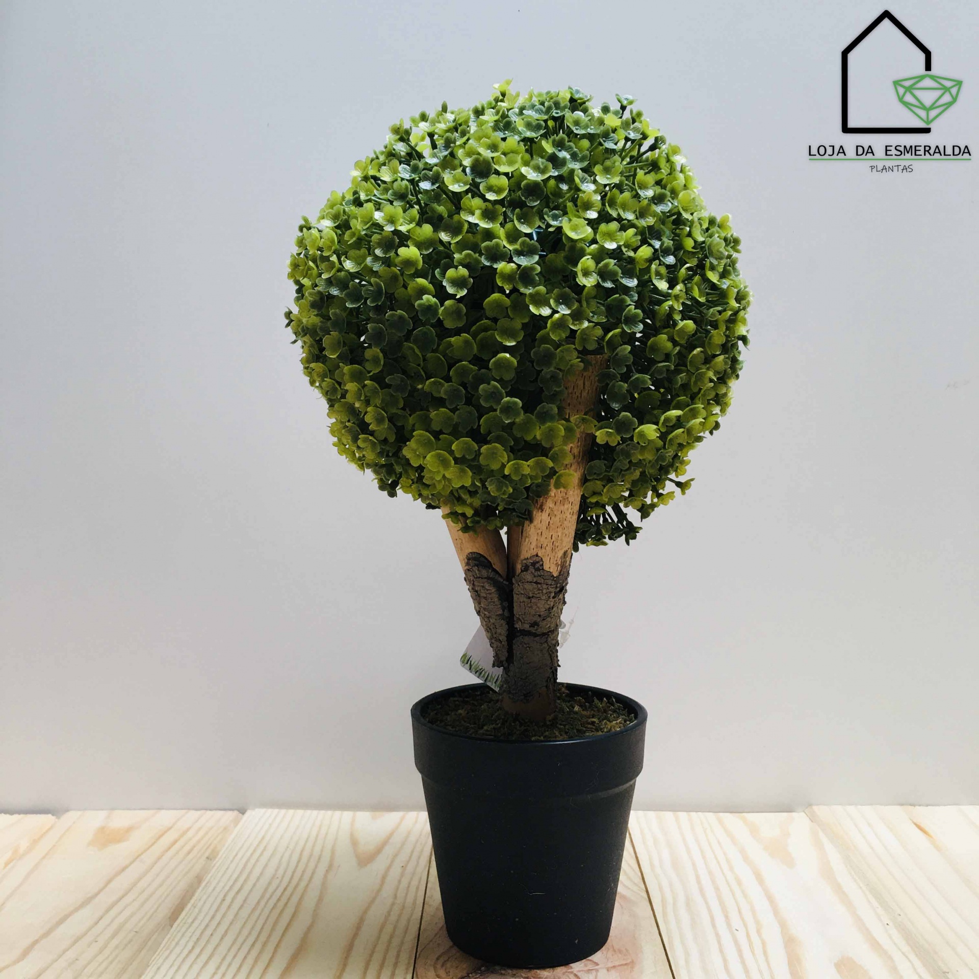 Planta artificial em vaso preto com folhas verdes redondas