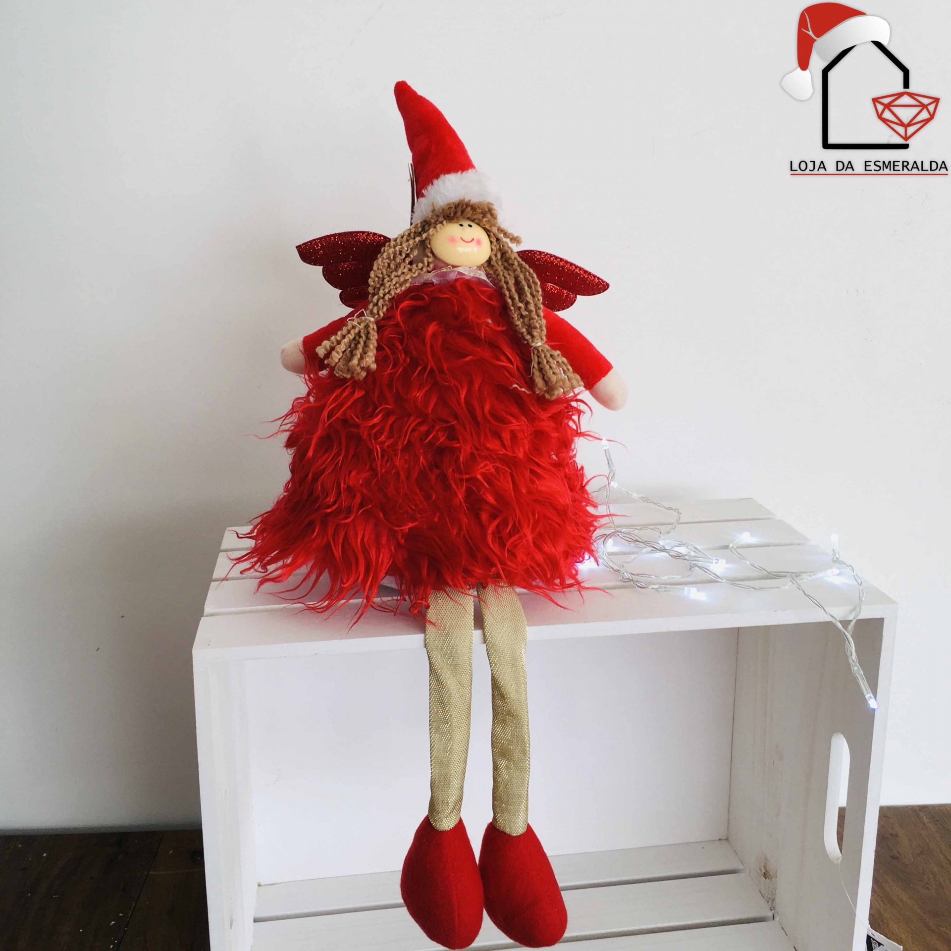 Boneca decorativa de Natal com vestido vermelho sentado sobre caixa branca