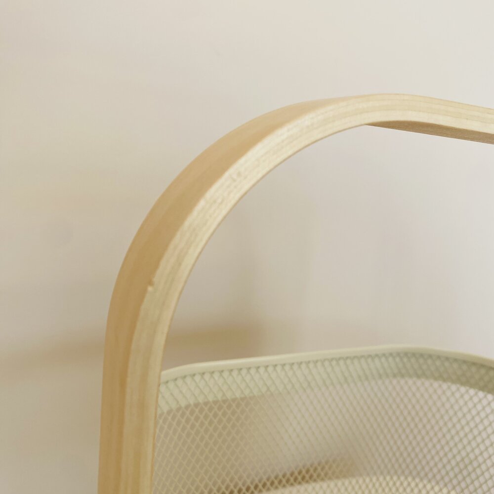 Cesto em metal verde claro com pega em madeira clara curvada