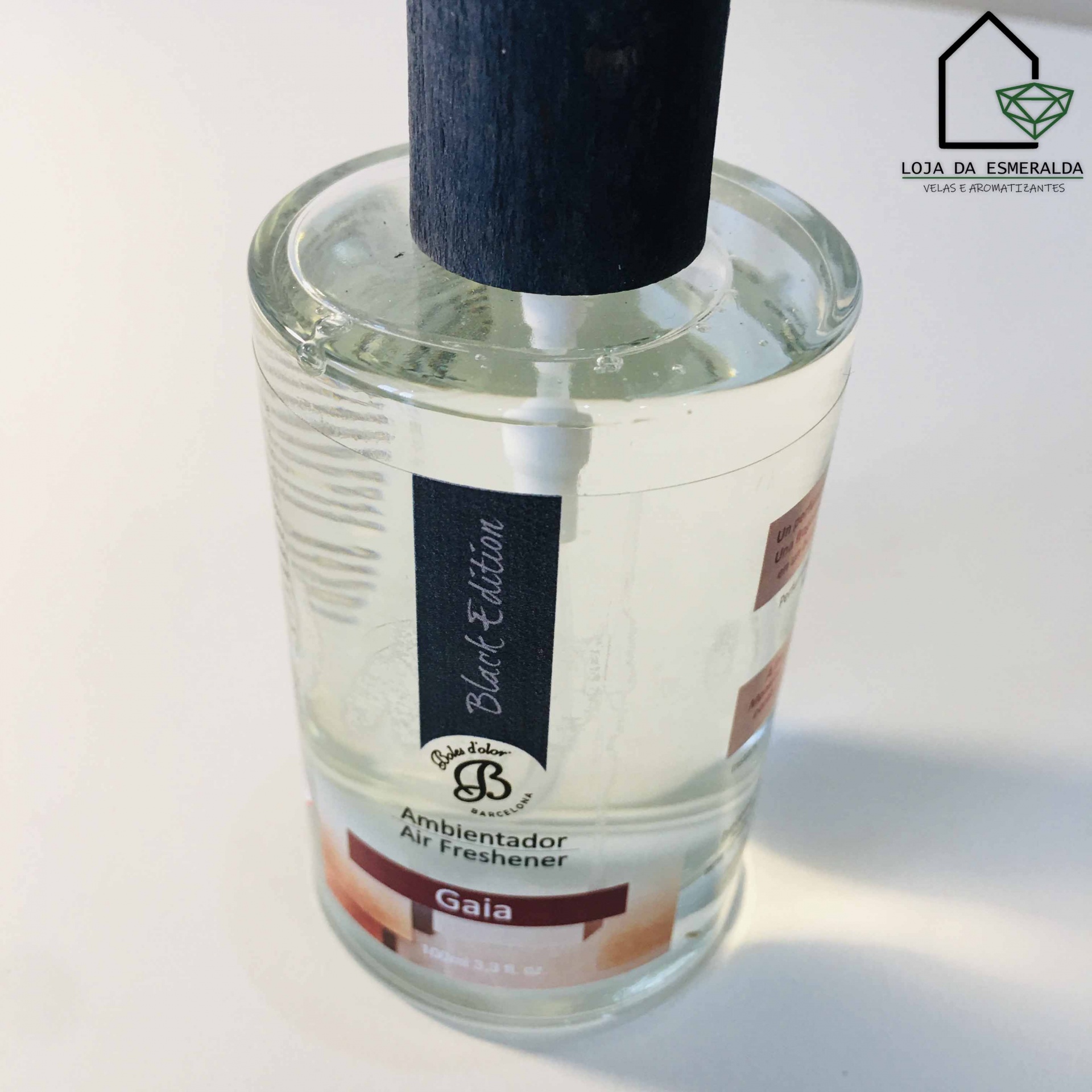 Frasco transparente de ambientador Gaia com tampa preta em madeira e etiquetas pretas e brancas