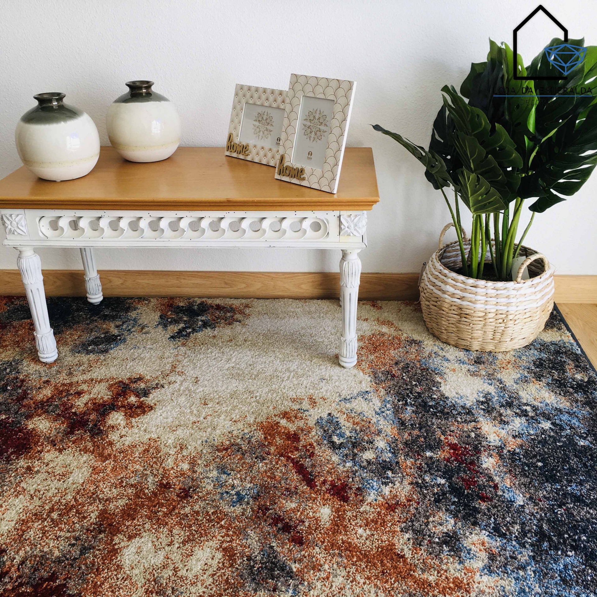 Tapete abstrato colorido com banco branco e planta em vaso de palha