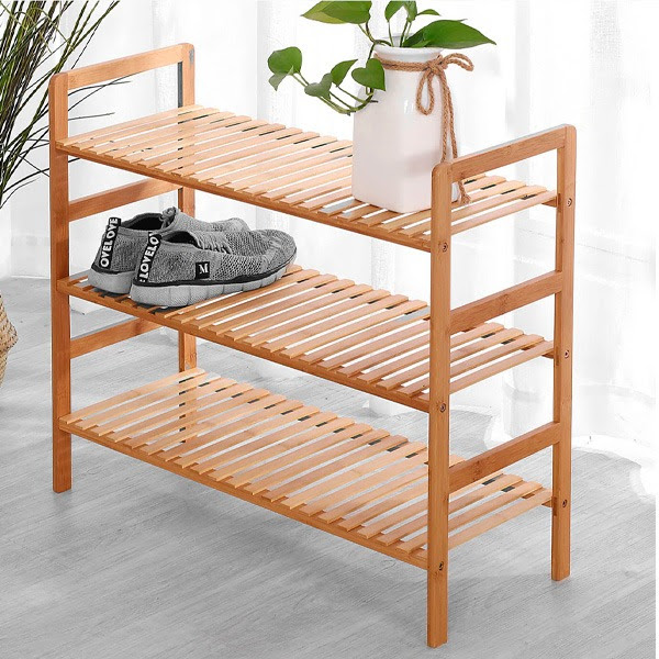 Estante organizadora de madeira com sapatos e planta