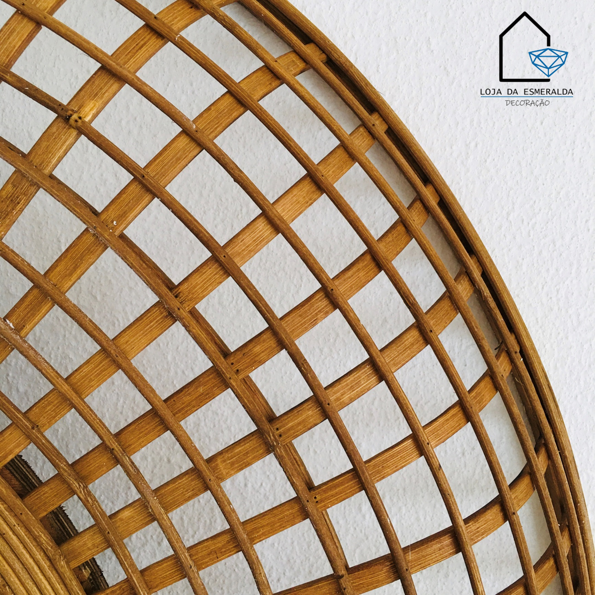 Estrutura decorativa circular de madeira com padrão trançado contra parede branca