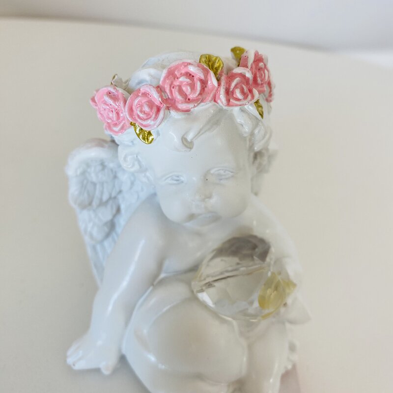 Estatueta de anjo branco com coroa rosa e bola de cristal