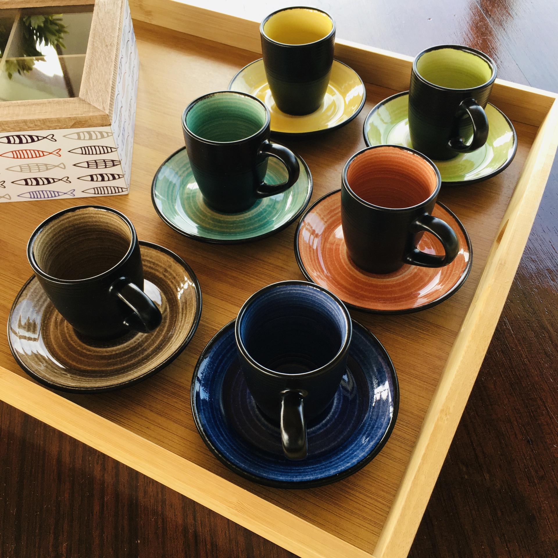 Conjunto de seis chávenas de café com pires coloridos em bandeja de madeira