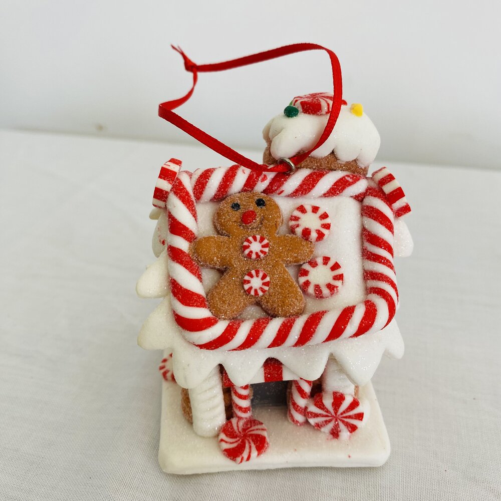 Casinha decorativa de Natal vermelha e branca com biscoito de gengibre e doces