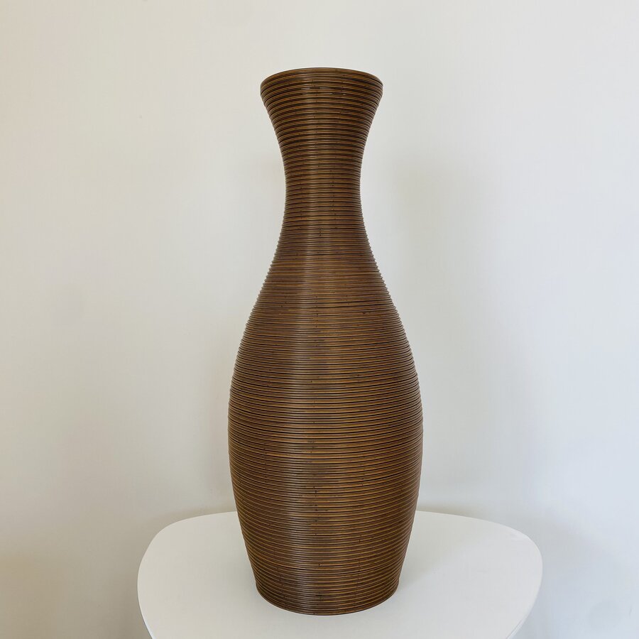 Vaso decorativo castanho com textura em linhas horizontais sobre mesa branca