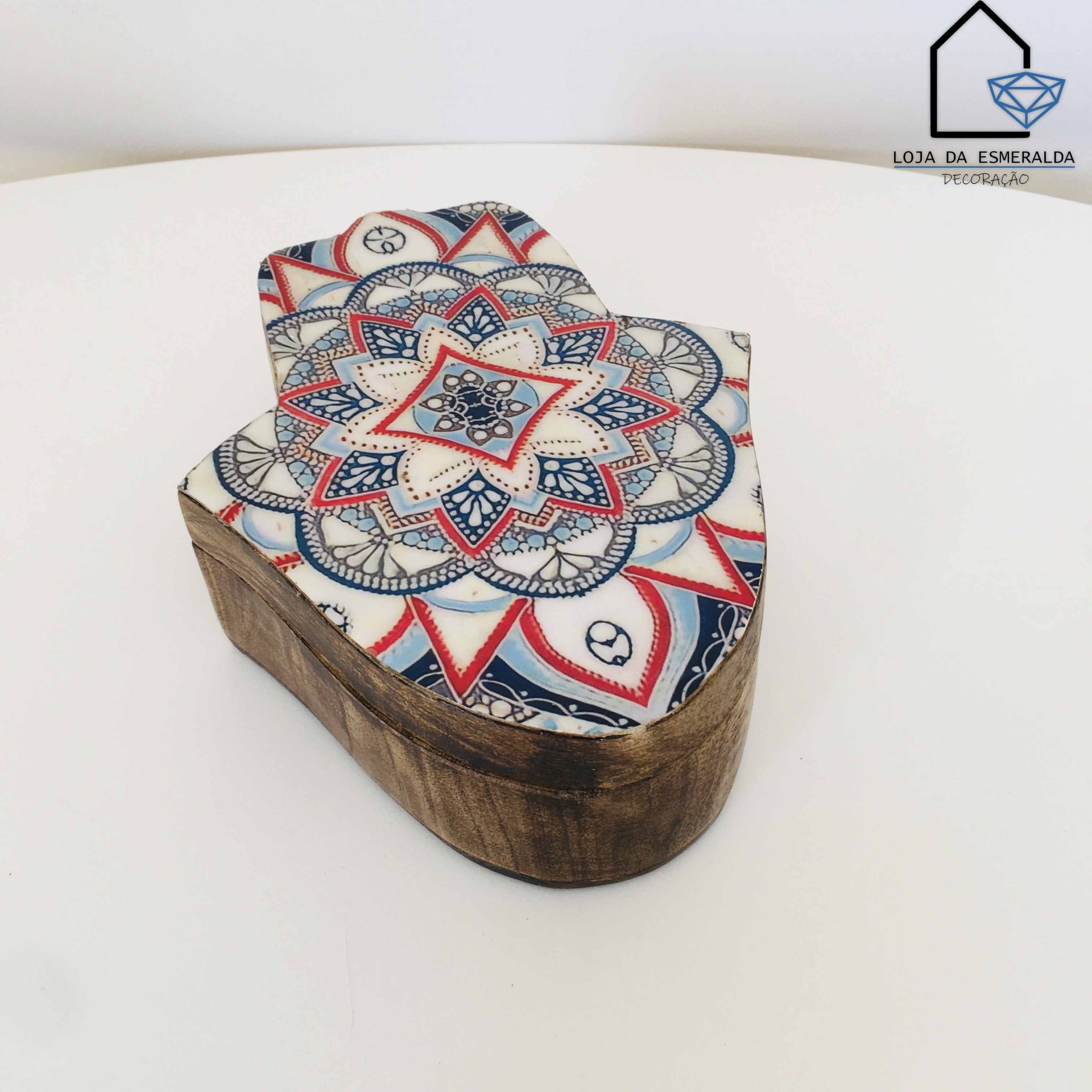 Caixa decorativa em forma de mão com padrão geométrico e floral azul, vermelho e branco