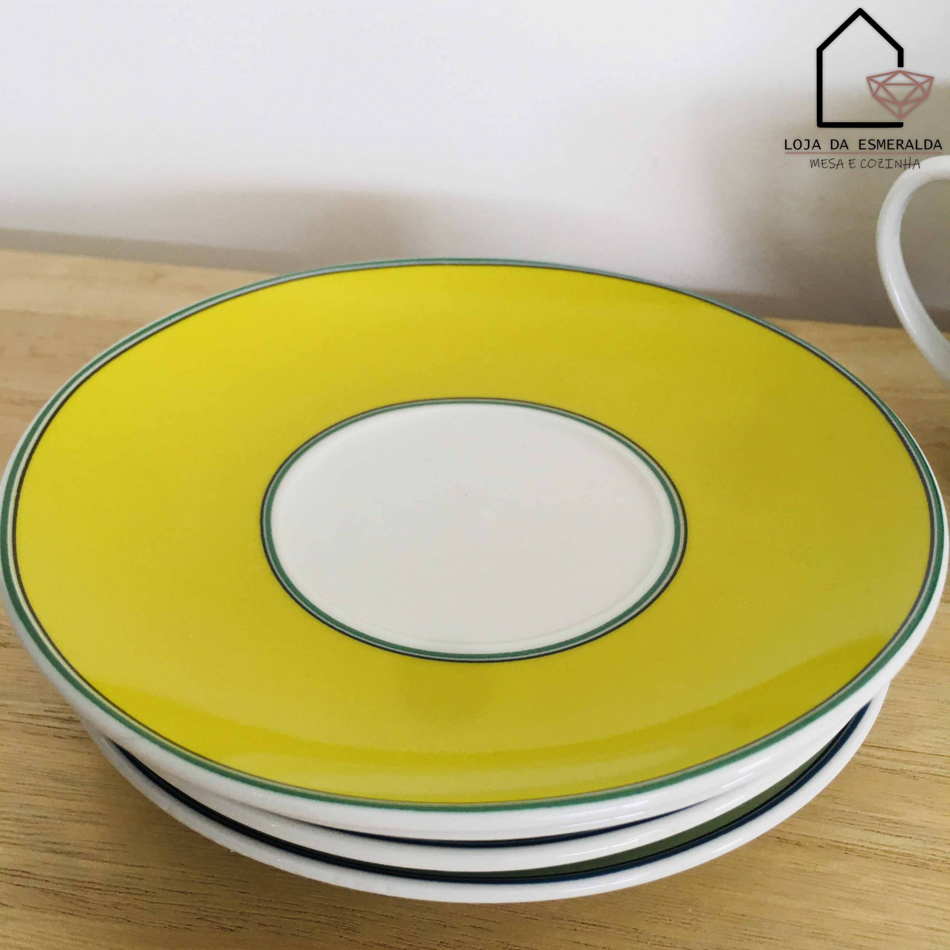 Pratos de cerâmica com borda amarela sobre mesa de madeira