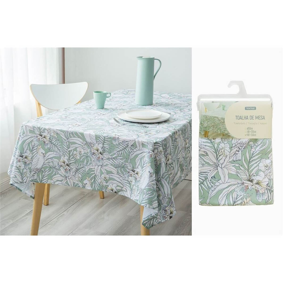 Toalha de mesa estampada com folhas verdes e flores brancas em mesa com jarro e copo verdes, embalagem com etiqueta