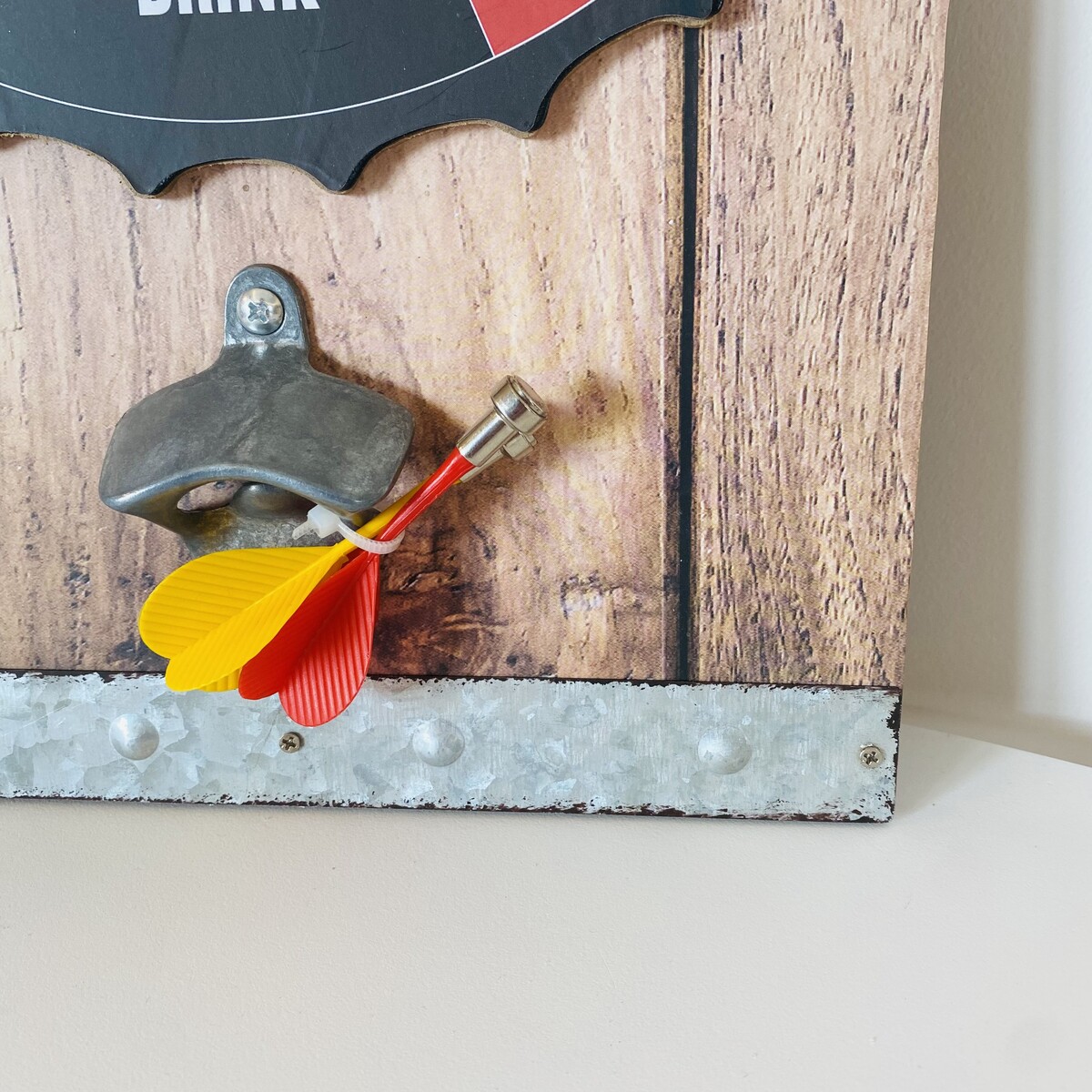 saca-rolhas fixado numa placa de madeira com setas de dardo coloridas