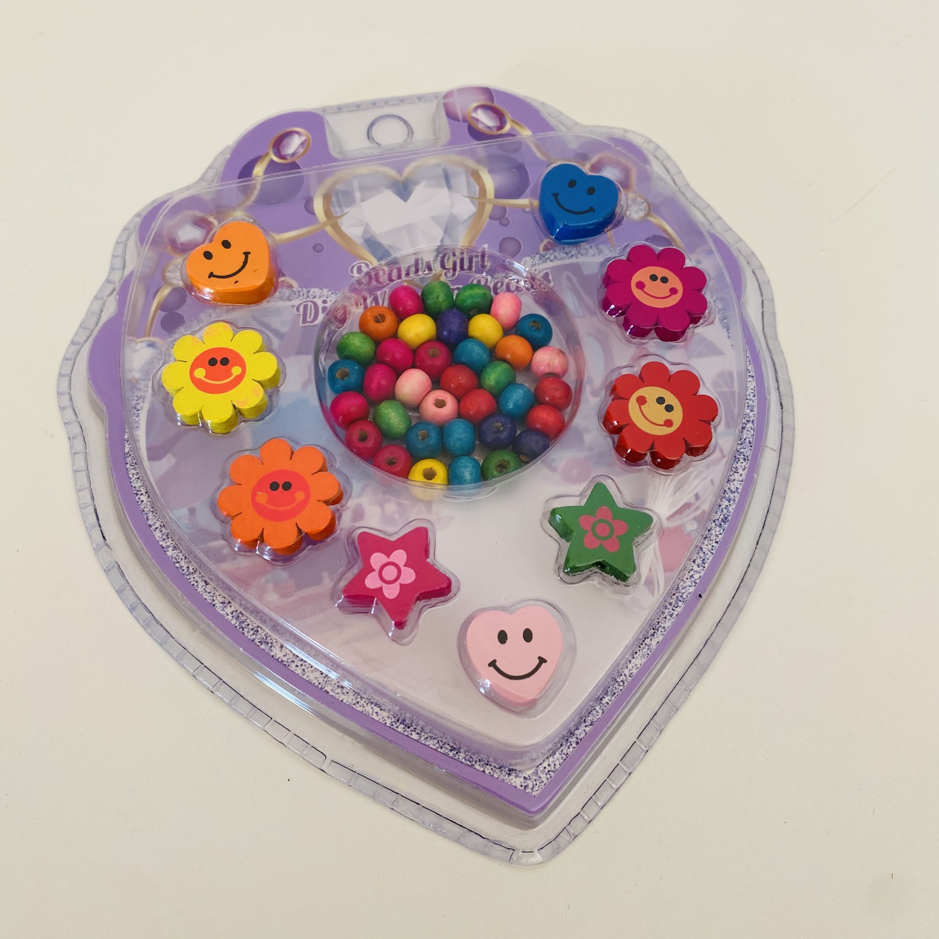 Colar infantil colorido com contas e pendentes em cartão lilás