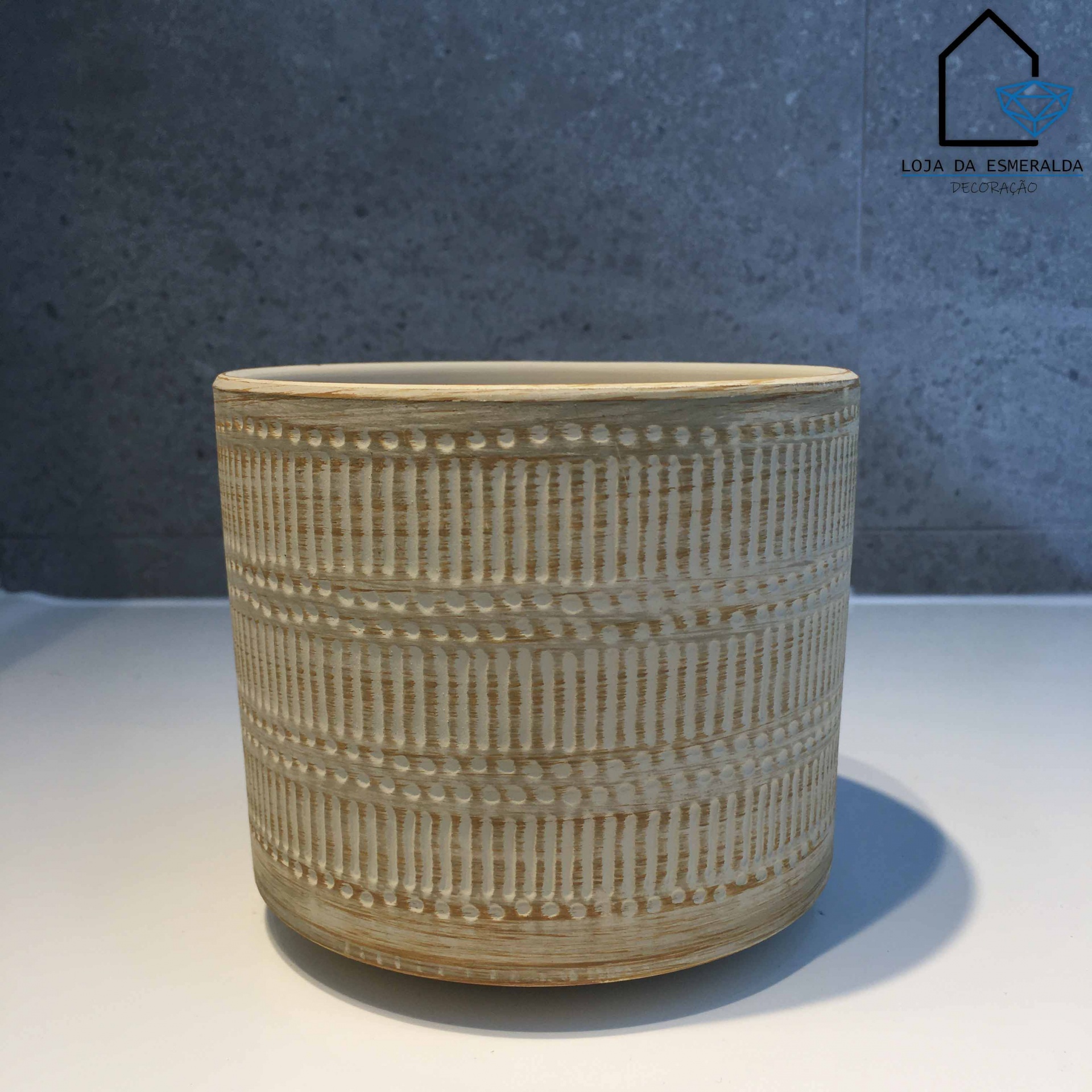Vaso de cerâmica bege com relevo geométrico, fundo cinza e logo Loja da Esmeralda