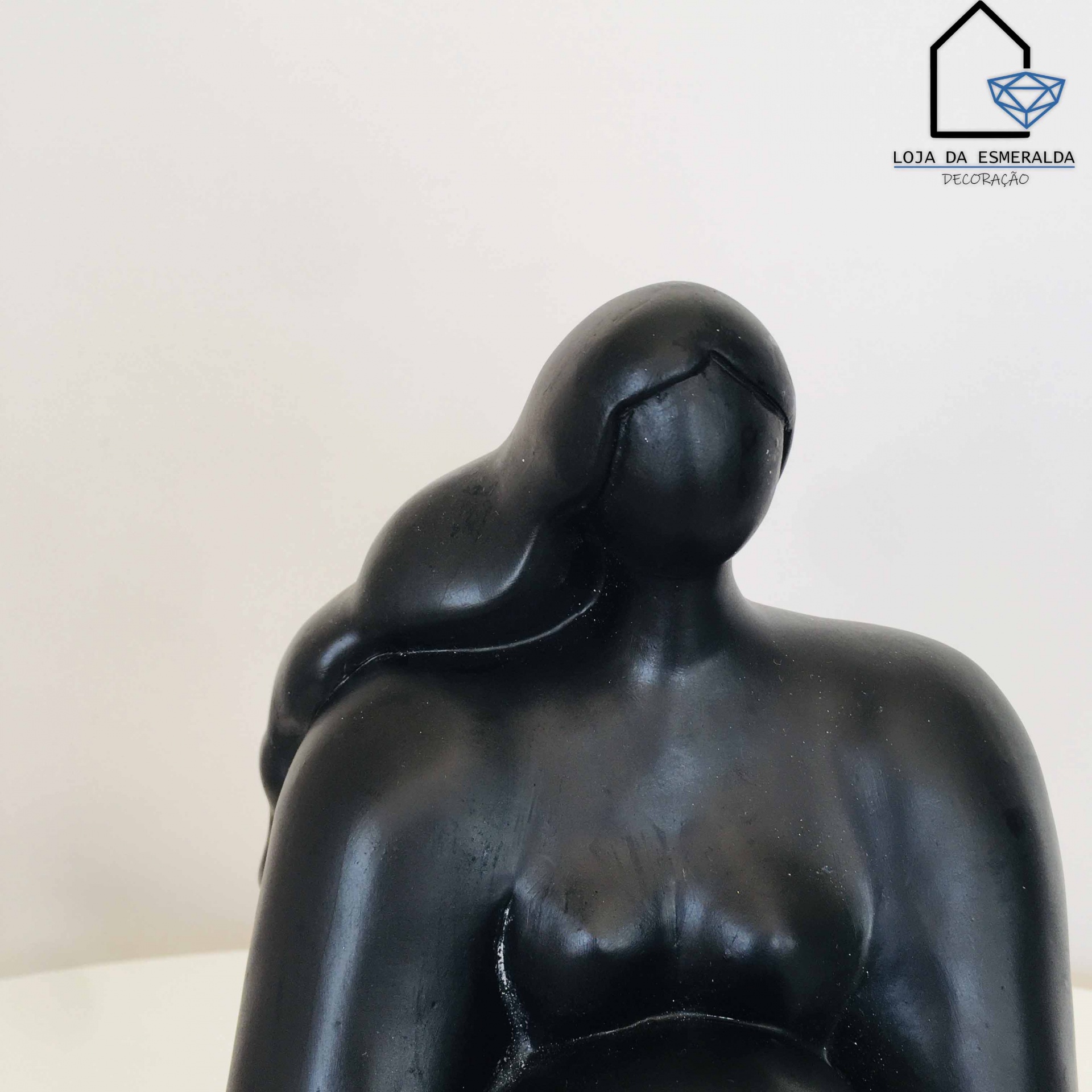 Escultura decorativa preta de figura feminina estilizada com logo Loja da Esmeralda