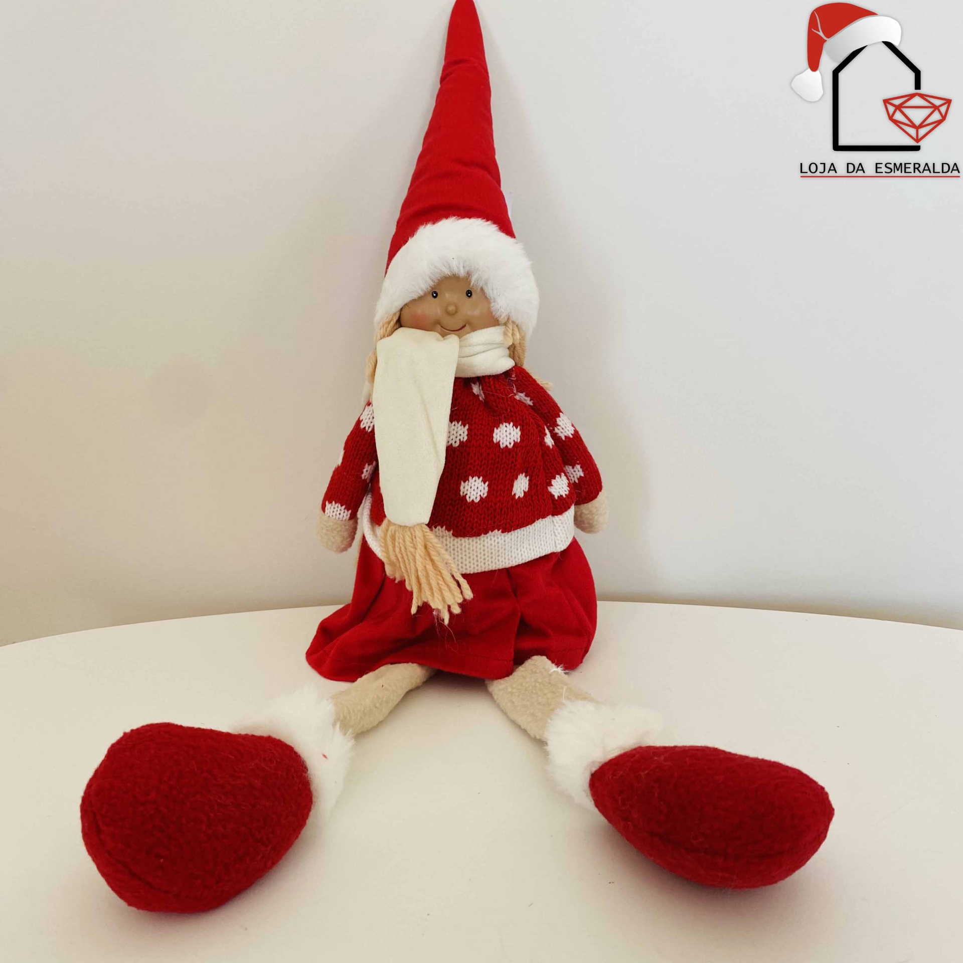 Boneco decorativo de Natal vermelho e branco sentado numa mesa