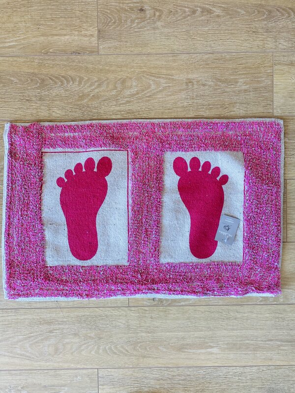 Tapete rectangular rosa com pegadas cor-de-rosa em fundo branco